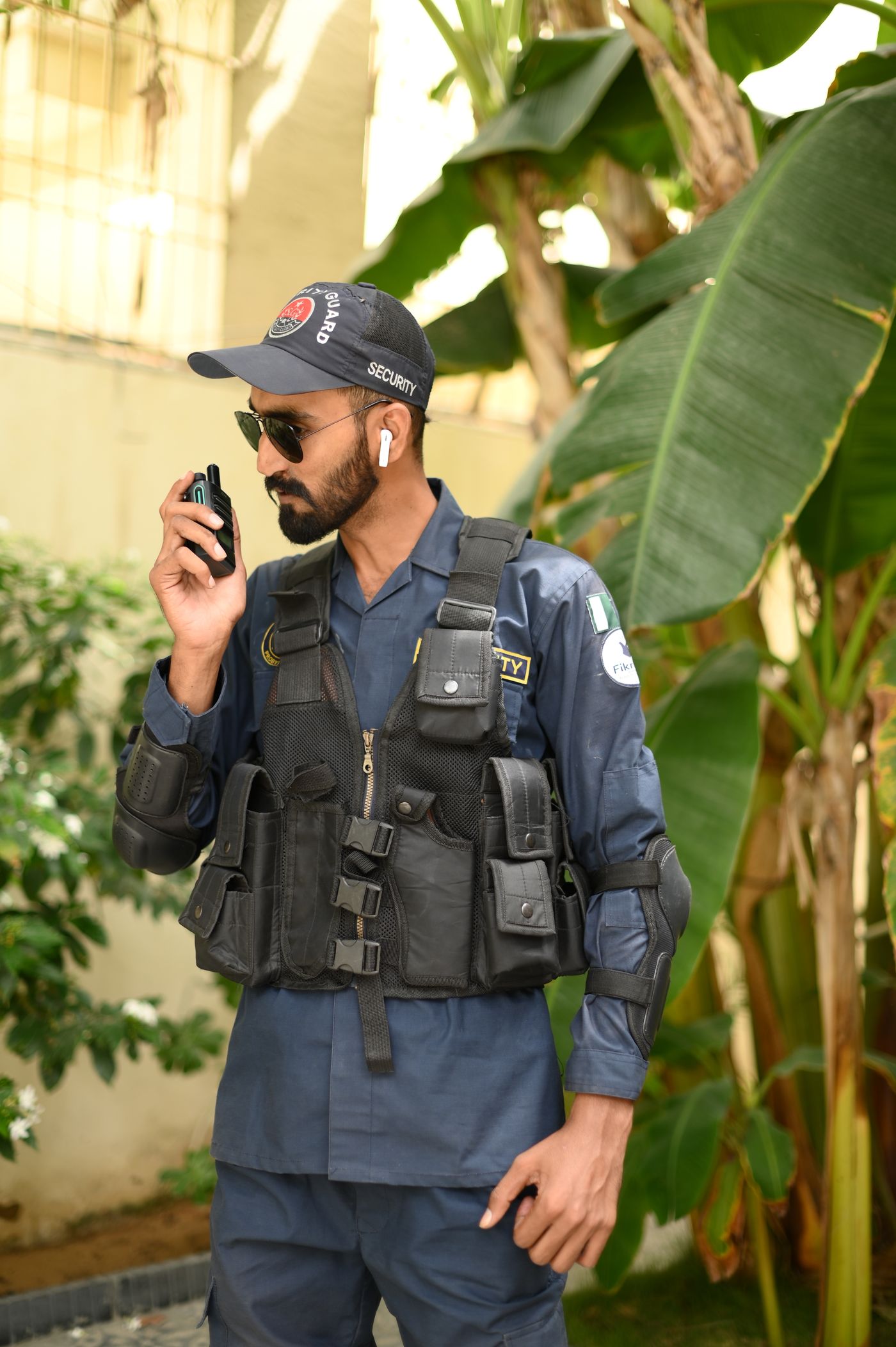Uniformed security guard speaking into a radio
